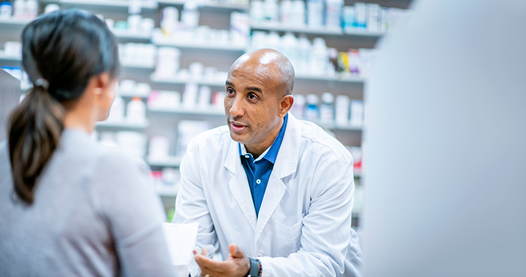Pharmacien offrant des explications à une cliente.
